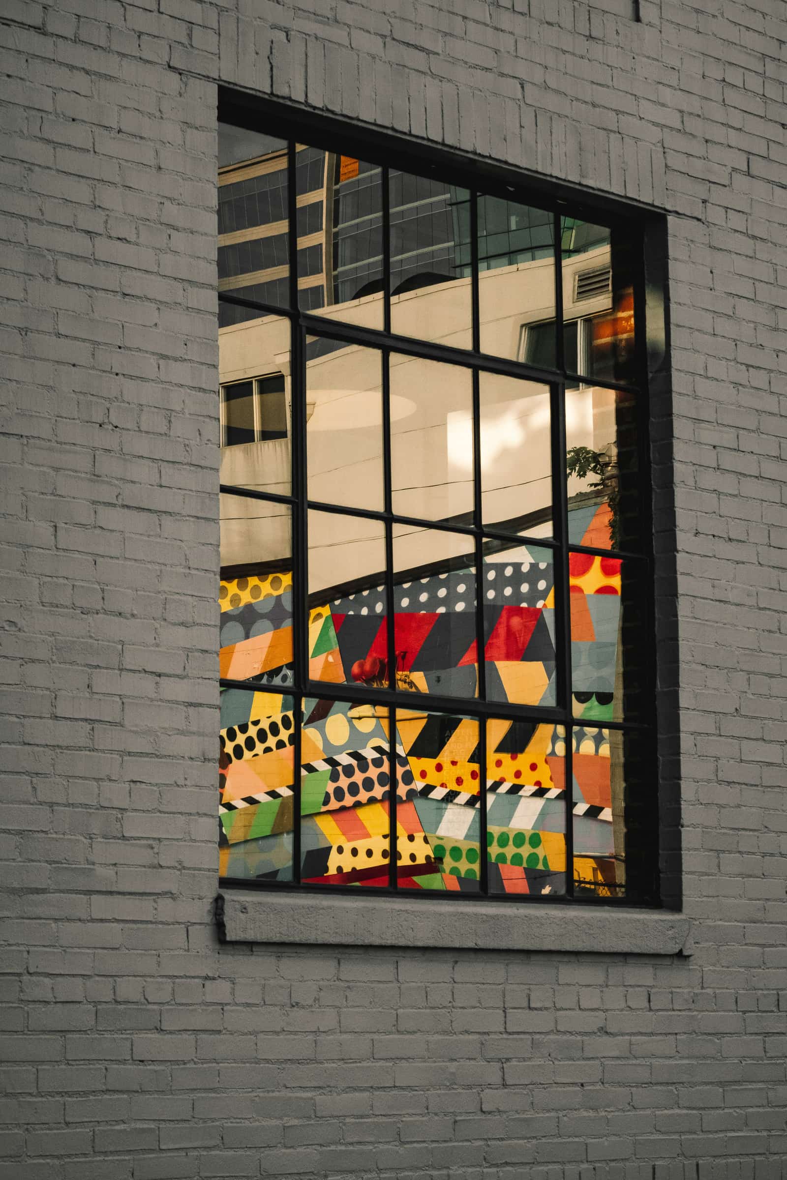A mural reflected in a window in the Gulch, Nashville
